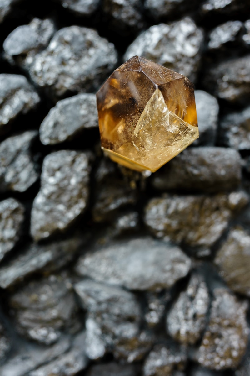 Photo by Eugene Chystiakov a yellow diamond sitting on top of a pile of rocks